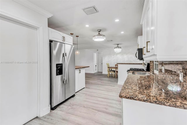 kitchen featuring sink, hanging light fixtures, stainless steel fridge with ice dispenser, light hardwood / wood-style floors, and white cabinets