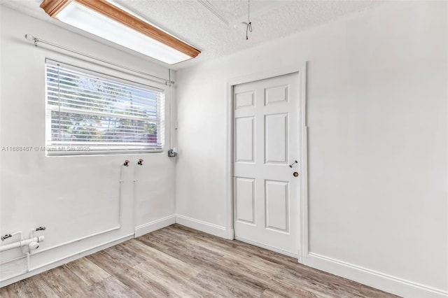 empty room featuring light hardwood / wood-style floors and a textured ceiling