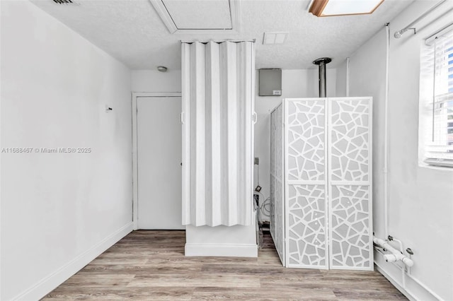 bathroom with hardwood / wood-style floors and a textured ceiling