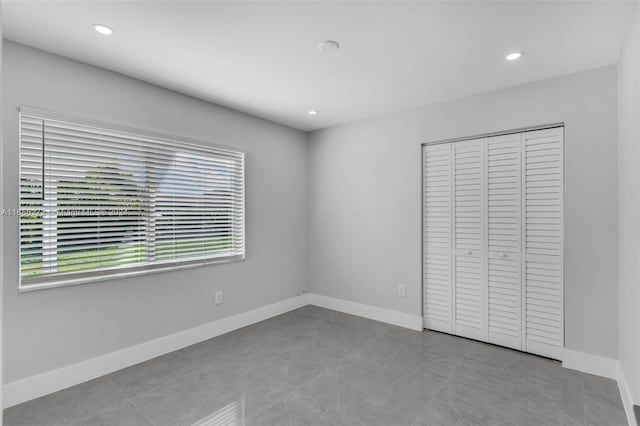 unfurnished bedroom with light tile patterned flooring and a closet