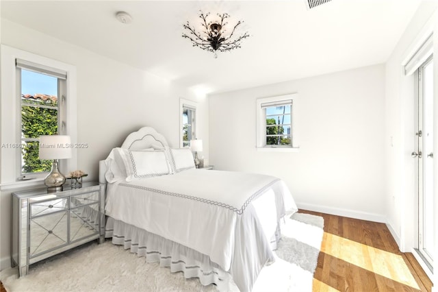 bedroom with wood-type flooring and multiple windows