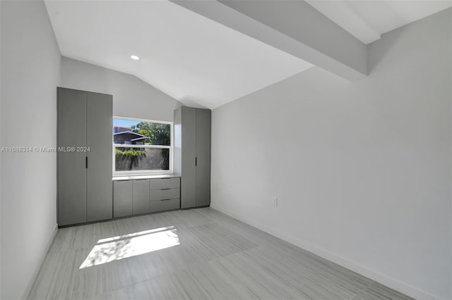 empty room featuring lofted ceiling