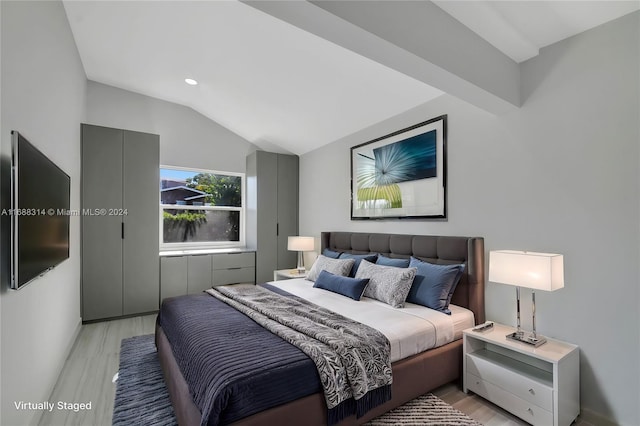 bedroom featuring light hardwood / wood-style floors and lofted ceiling