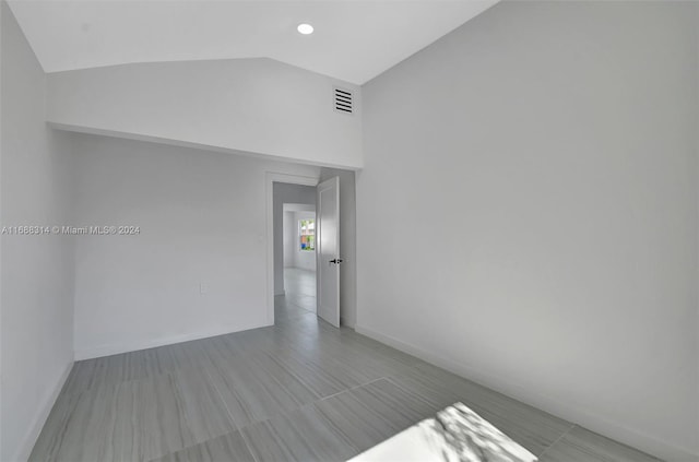 empty room featuring lofted ceiling