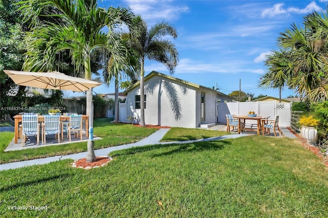 back of property featuring a yard and a patio