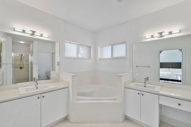 bathroom with tile patterned floors, vanity, and plus walk in shower