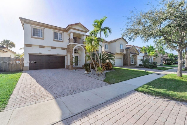 view of front of property with a garage, a balcony, and a front lawn