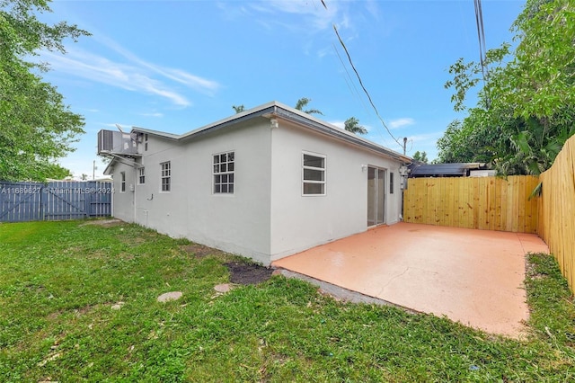 rear view of house featuring a yard and a patio