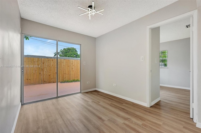 empty room with light wood-type flooring, a textured ceiling, and ceiling fan