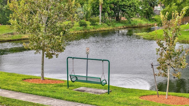 view of property's community featuring a lawn and a water view