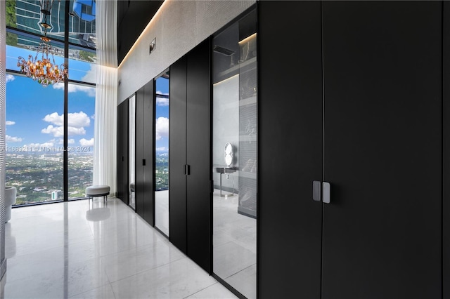 hallway with expansive windows and light tile patterned flooring