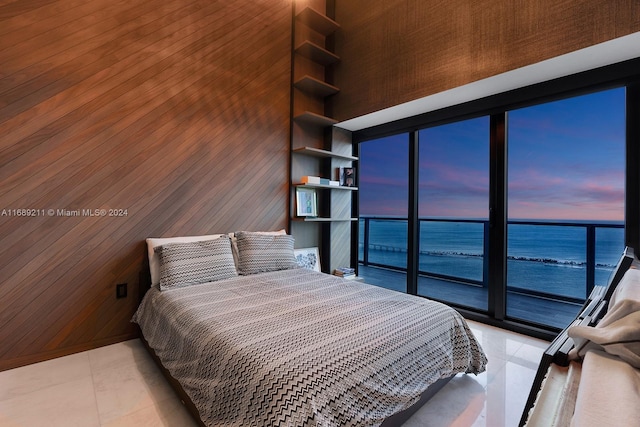 bedroom with a water view and wood walls