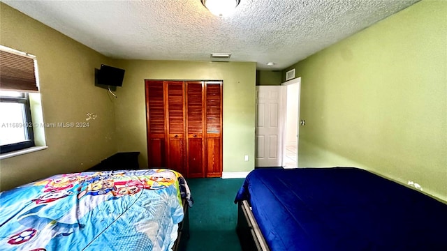 bedroom featuring a textured ceiling, a closet, and carpet