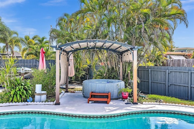 view of pool featuring a jacuzzi and a patio area