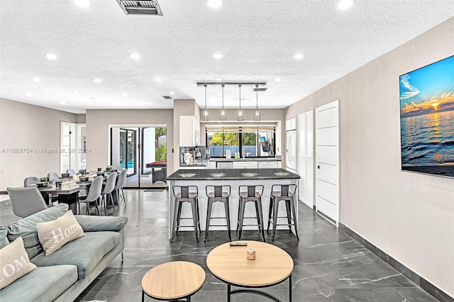 living room featuring rail lighting and a textured ceiling