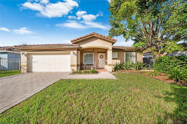 mediterranean / spanish-style house with a front yard and a garage