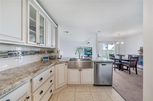 kitchen featuring light stone countertops, sink, stainless steel dishwasher, a chandelier, and light tile patterned floors