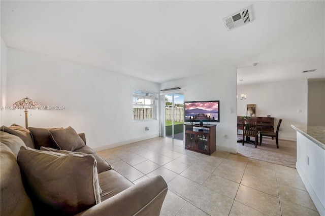 living room with an inviting chandelier and light tile patterned flooring