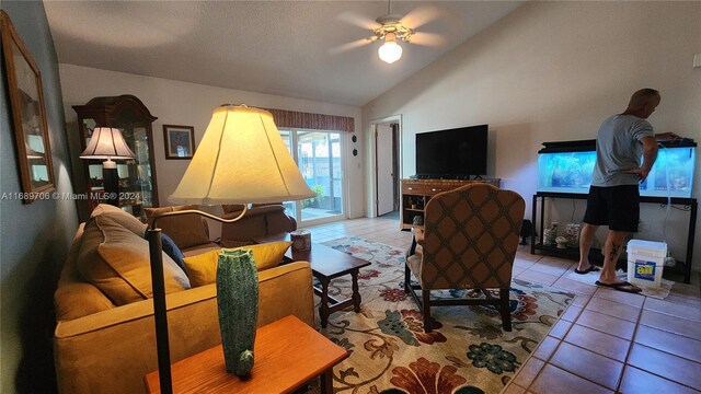 living room featuring high vaulted ceiling, ceiling fan, and light tile patterned floors