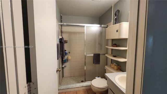 bathroom with toilet, vanity, tile patterned floors, and a shower with door