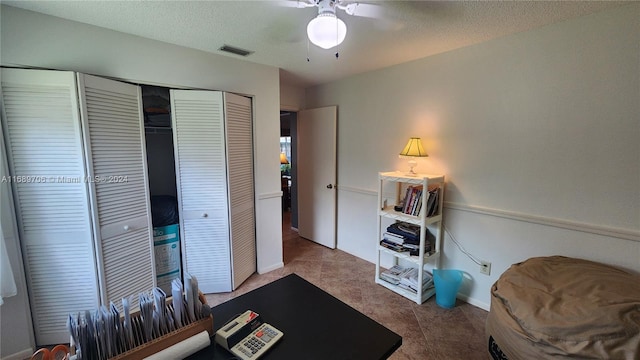 office area featuring ceiling fan, a textured ceiling, and tile patterned flooring