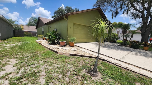 view of property exterior featuring a garage and a lawn