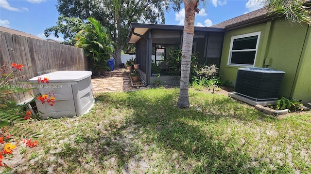 view of yard featuring central AC unit and a sunroom