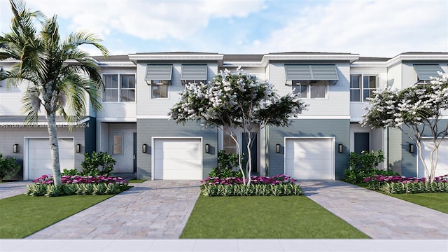 view of property featuring a garage and a front lawn