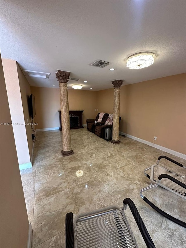 1250 W 61st Pl, Hialeah, FL 33012 - interior space featuring decorative columns, a textured ceiling, and baseboards