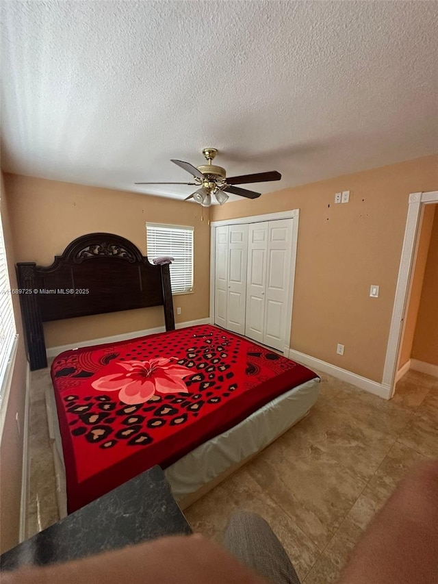 1250 W 61st Pl, Hialeah, FL 33012 - bedroom with a closet, a ceiling fan, a textured ceiling, and baseboards