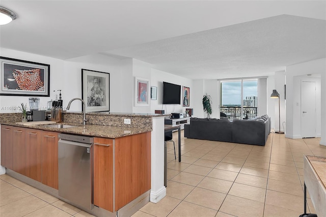 kitchen with dark stone counters, dishwasher, a textured ceiling, sink, and light tile patterned floors