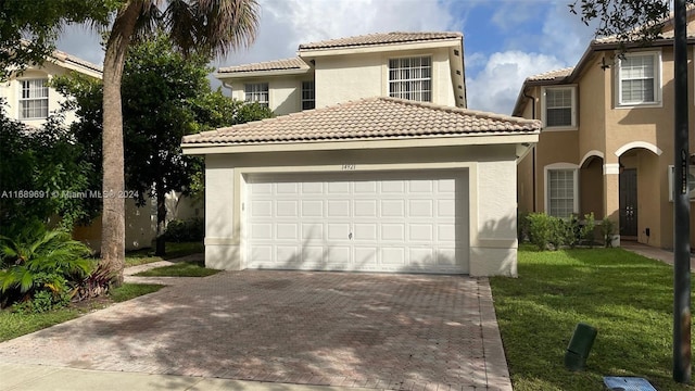 mediterranean / spanish-style house with a garage and a front lawn