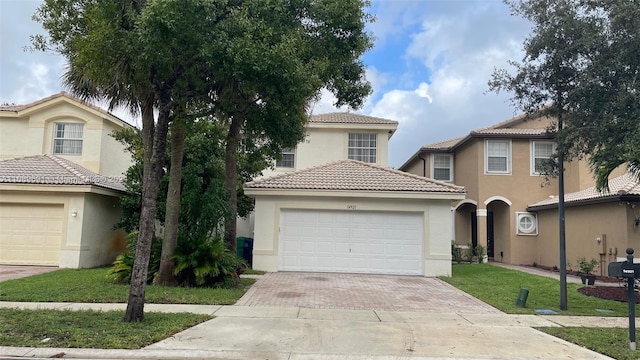 mediterranean / spanish-style house with a garage and a front lawn