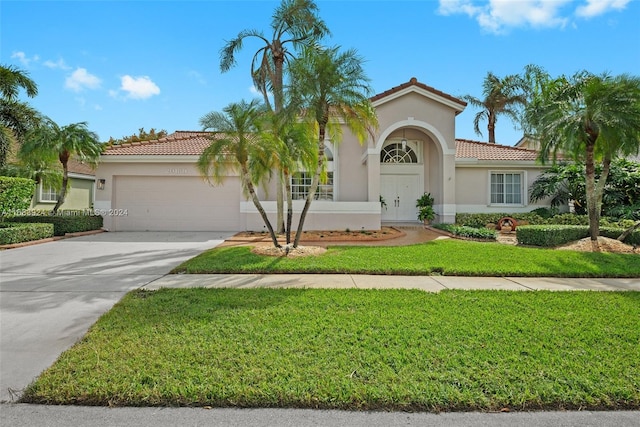 mediterranean / spanish house featuring a garage and a front yard