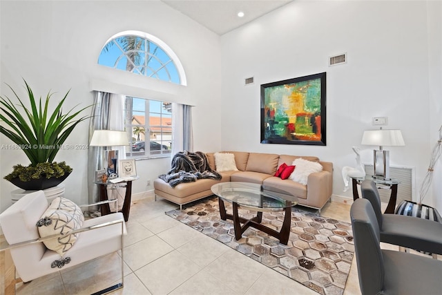 living room featuring a towering ceiling and light tile patterned flooring