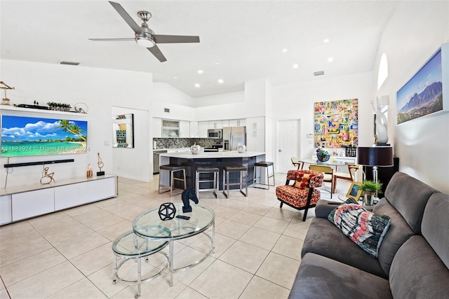 living room featuring ceiling fan, light tile patterned floors, and high vaulted ceiling