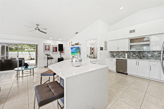 kitchen featuring dishwasher, white cabinetry, lofted ceiling, and a center island