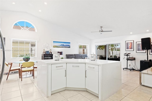 kitchen featuring white cabinets, a healthy amount of sunlight, vaulted ceiling, and a center island