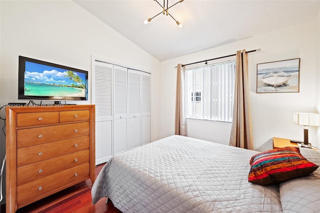 bedroom with dark hardwood / wood-style floors, a closet, and lofted ceiling