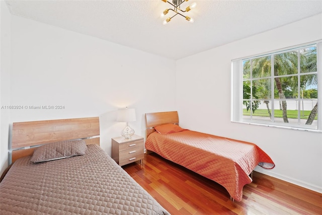 bedroom featuring hardwood / wood-style floors and a notable chandelier