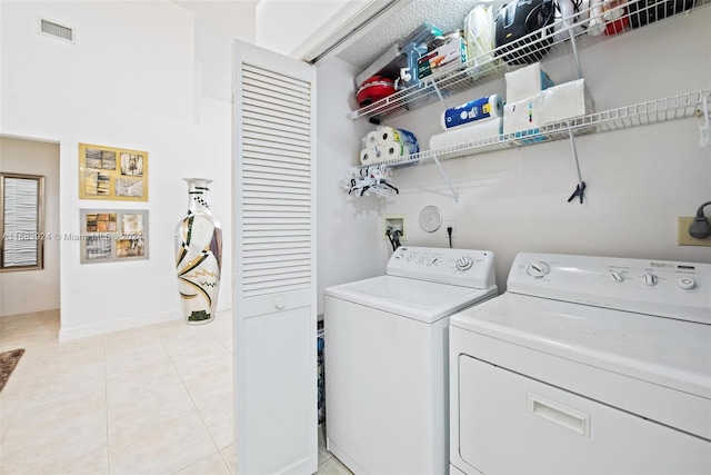 laundry area featuring washing machine and dryer and light tile patterned floors