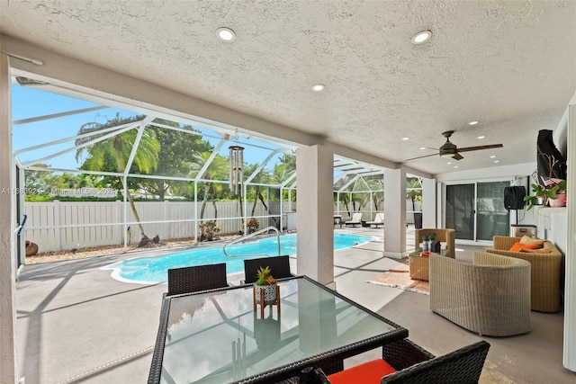 view of swimming pool with a lanai, ceiling fan, and a patio area