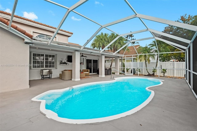 view of pool featuring a lanai, ceiling fan, and a patio