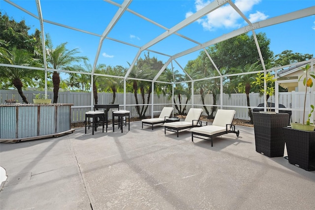 view of patio featuring glass enclosure