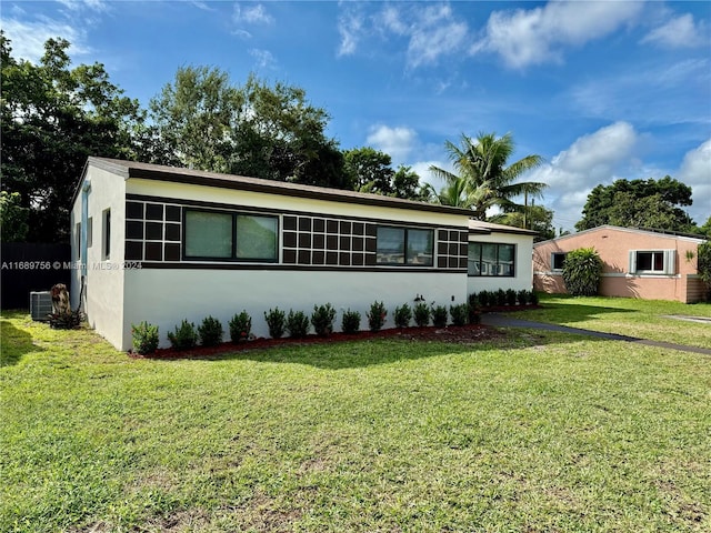 ranch-style house with a front lawn and central AC unit