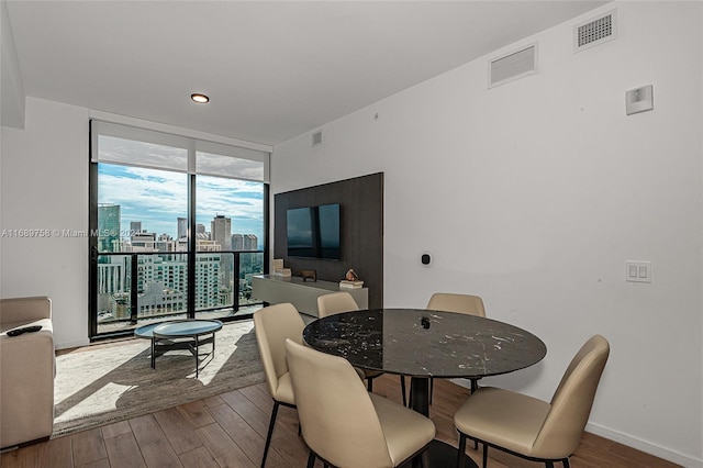 dining room featuring wood-type flooring and floor to ceiling windows