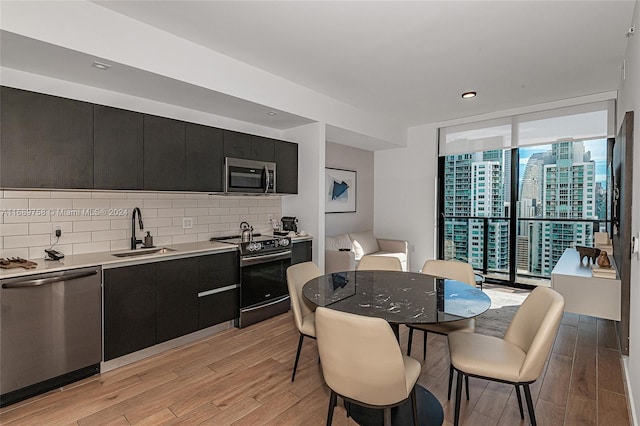 dining area featuring expansive windows, light hardwood / wood-style floors, and sink