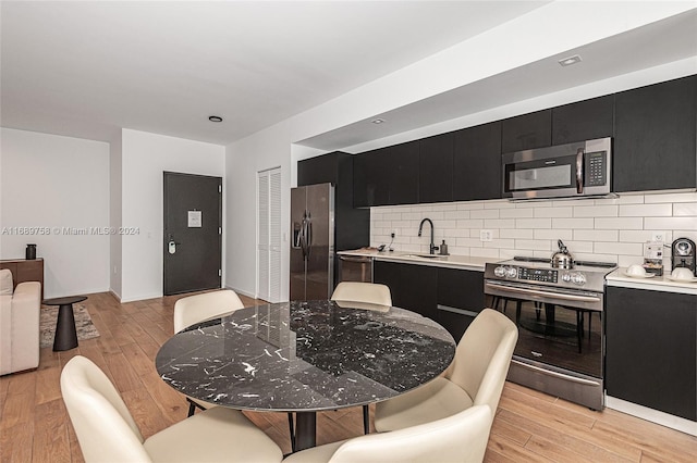 dining room featuring sink and light wood-type flooring