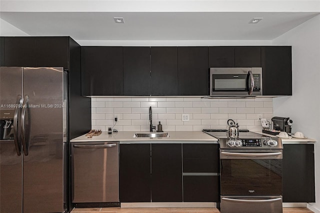 kitchen with tasteful backsplash, appliances with stainless steel finishes, and sink