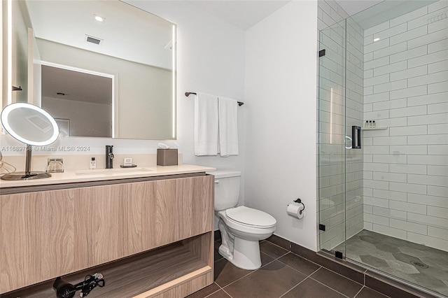 bathroom featuring toilet, an enclosed shower, vanity, and tile patterned floors